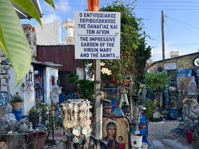 Schild „Garten der Jungfrau Maria und der Heiligen“ mit Ikone im Garten des Blue Shell House