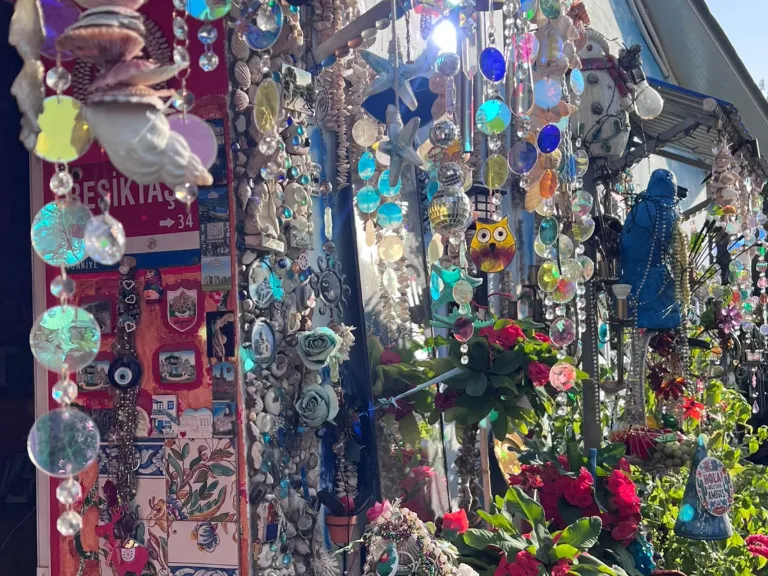 Glasanhänger, Muscheln und Blumen an der Fassade des Blue Shell House
