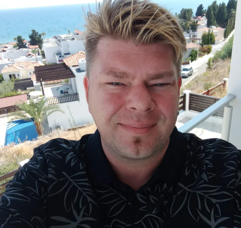 Christian, host of Coral Bay Holiday Villas, on a sea-view balcony in Coral Bay